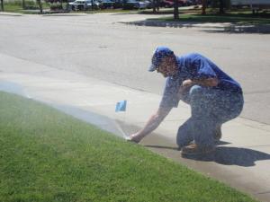 a Rocklin Sprinkler Repair tech adjusts a pop up head