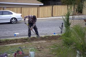 a Rocklin Irrigation Repair tech trenches a new drain line